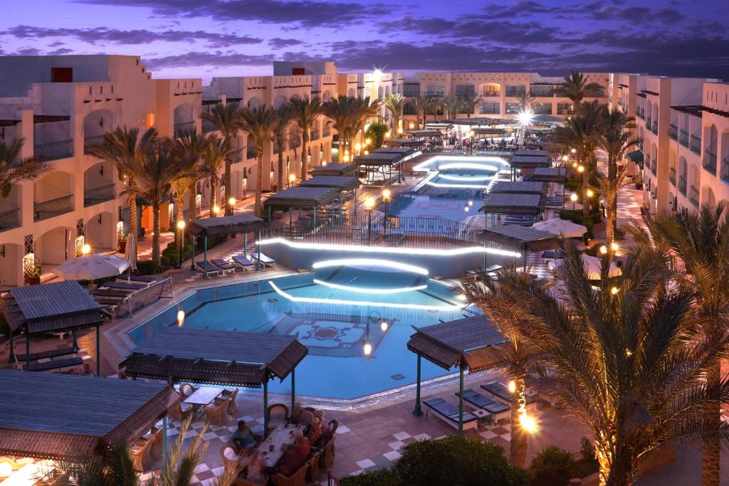 uma imagem de uma piscina de resort à noite em Bel Air Azur Resort (Adults Only) em Hurghada