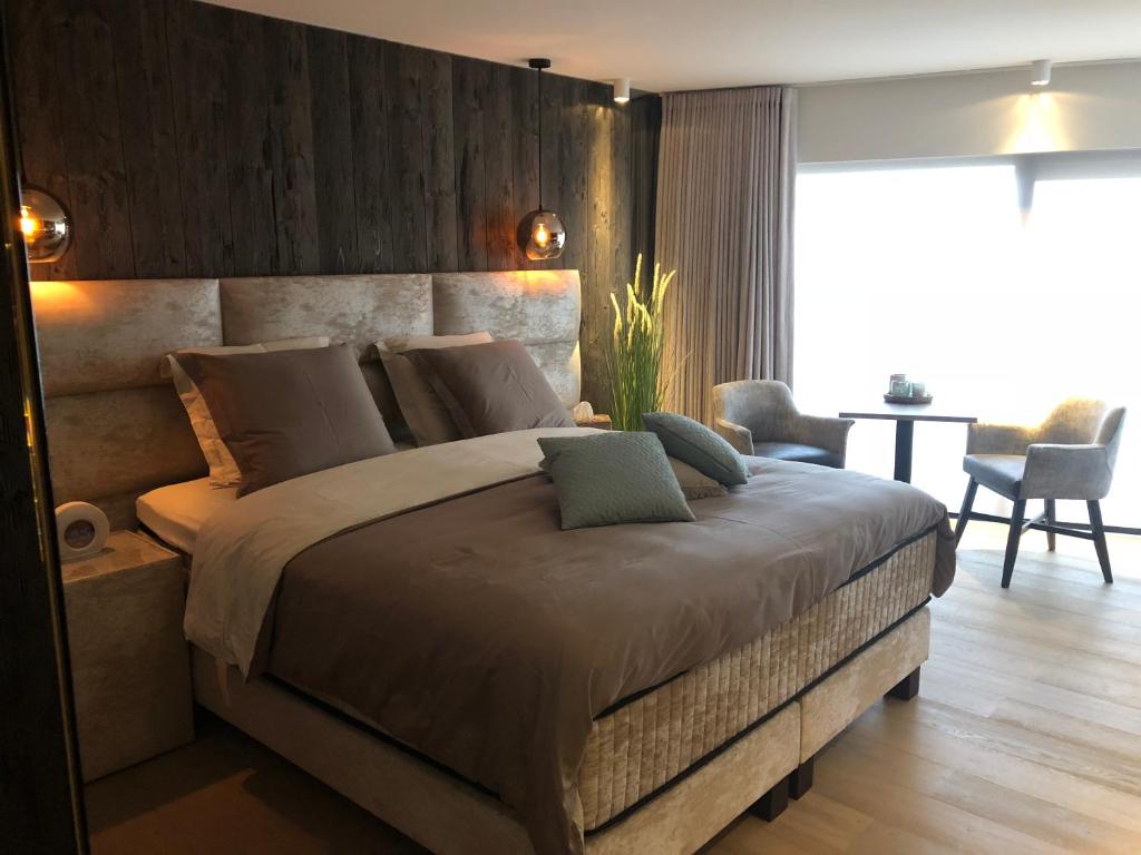 a bedroom with a large bed with a wooden wall at Le Sable Doux 4D in Middelkerke