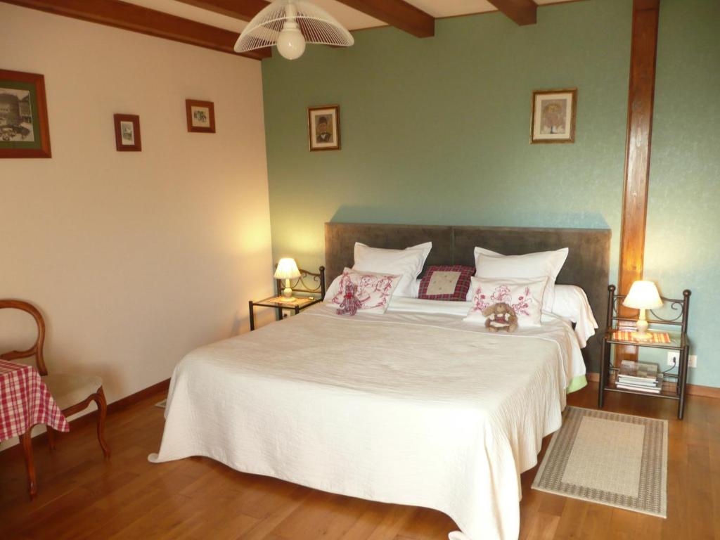 1 dormitorio con 1 cama blanca grande con almohadas rosas en Chez Anny et Jean Au Mittelbuehl, en Reichshoffen