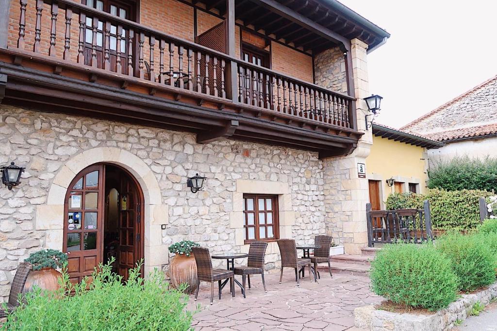 un patio con sillas y una mesa frente a un edificio en Trisileja en Posada La Busta, en La Busta