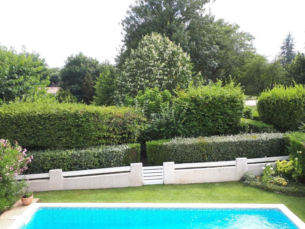 a swimming pool in the middle of a garden at Maison ruisseau l'eau blanche in Léognan