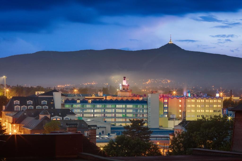 a city at night with a mountain in the background at Wellness Hotel Babylon in Liberec