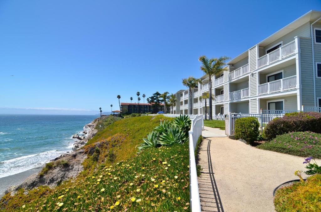 ein Gebäude mit einem Weg am Meer in der Unterkunft Pismo Lighthouse Suites in Pismo Beach