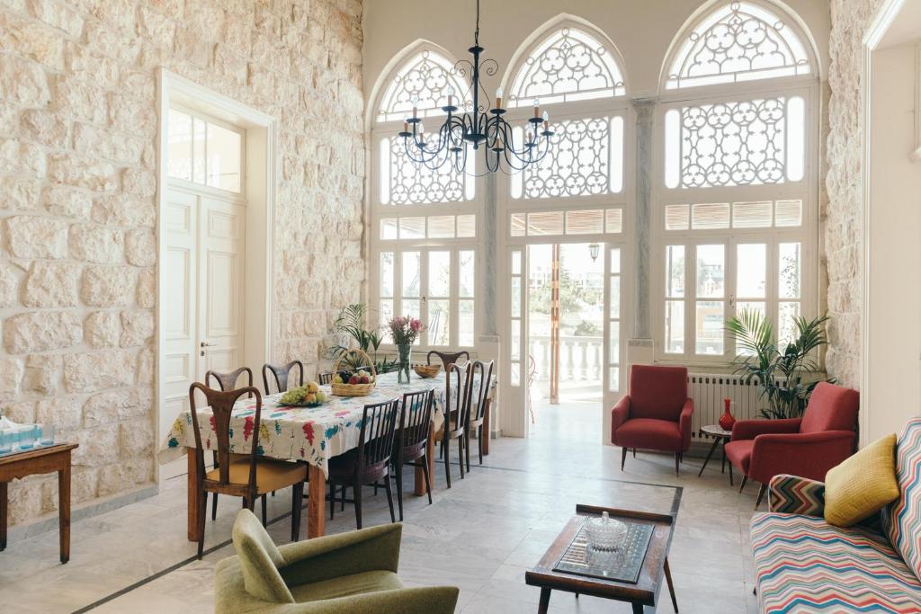 - un salon avec une table, des chaises et des fenêtres dans l'établissement Beit El Bahr, à Tabarja