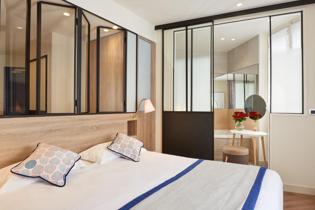 - une chambre avec un lit et des parois en verre dans l'établissement Hôtel de Sévigné, à Paris