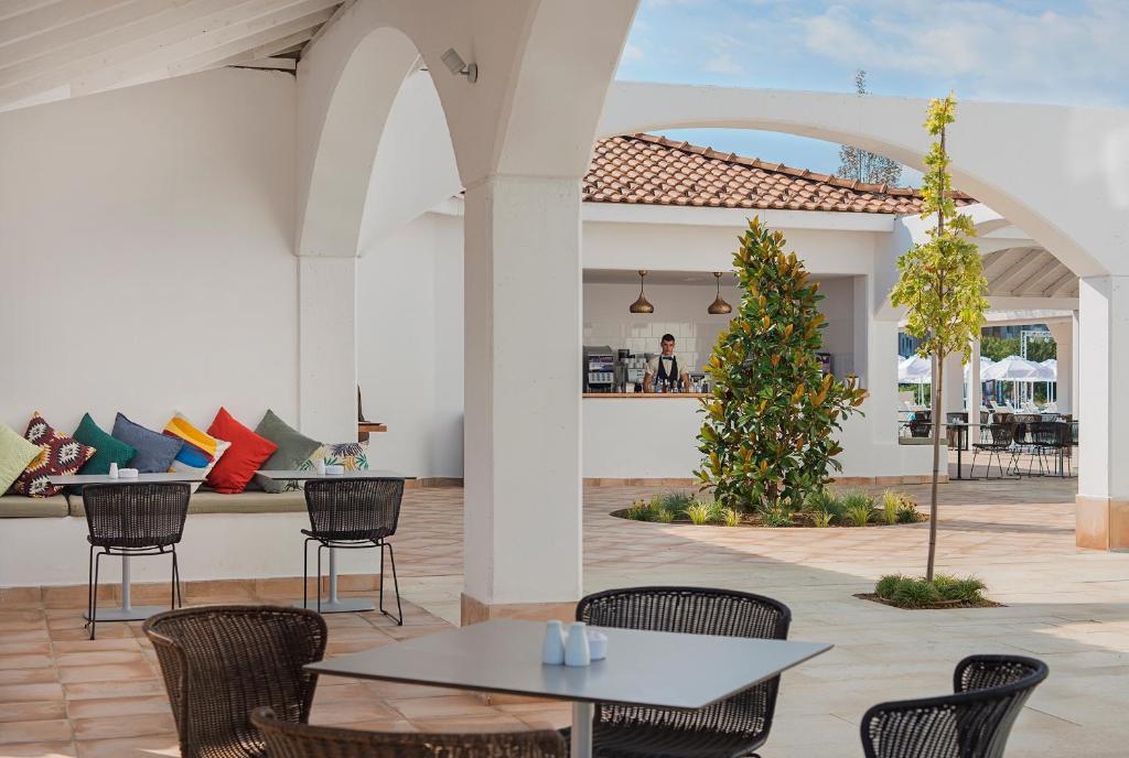 a patio with a table and chairs and a couch at Sunrise Blue Magic Resort - All Inclusive in Obzor