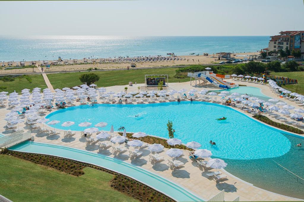 an overhead view of a pool with umbrellas and a beach at Sunrise Blue Magic Resort - All Inclusive in Obzor