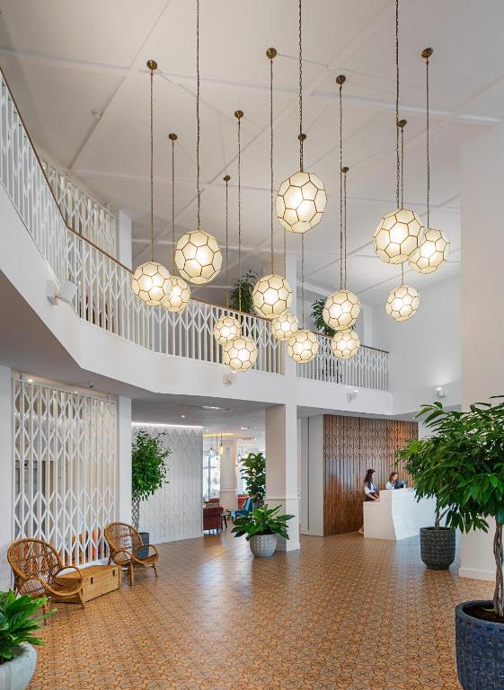 a lobby with potted plants and chandeliers at Sunrise Blue Magic Resort - All Inclusive in Obzor