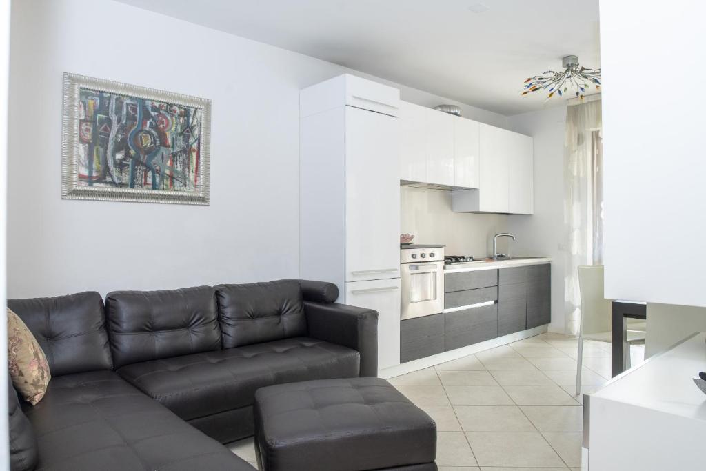 a living room with a couch and a kitchen at Fellini - Family Flat in Rimini
