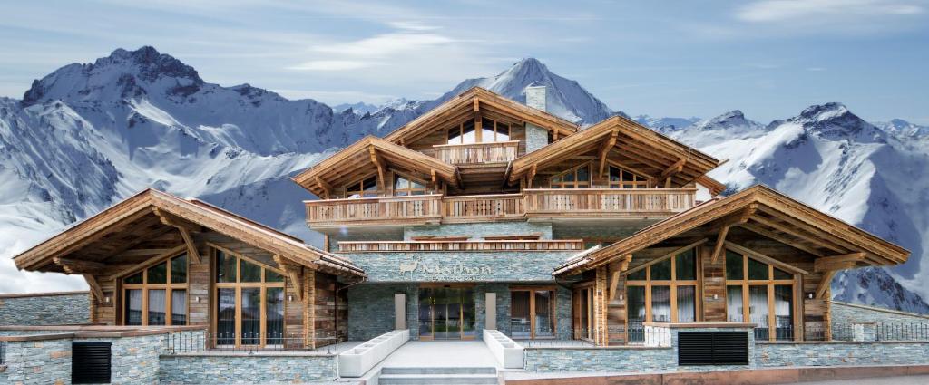 a mountain house with mountains in the background at Chalet Residences Mathon in Ischgl