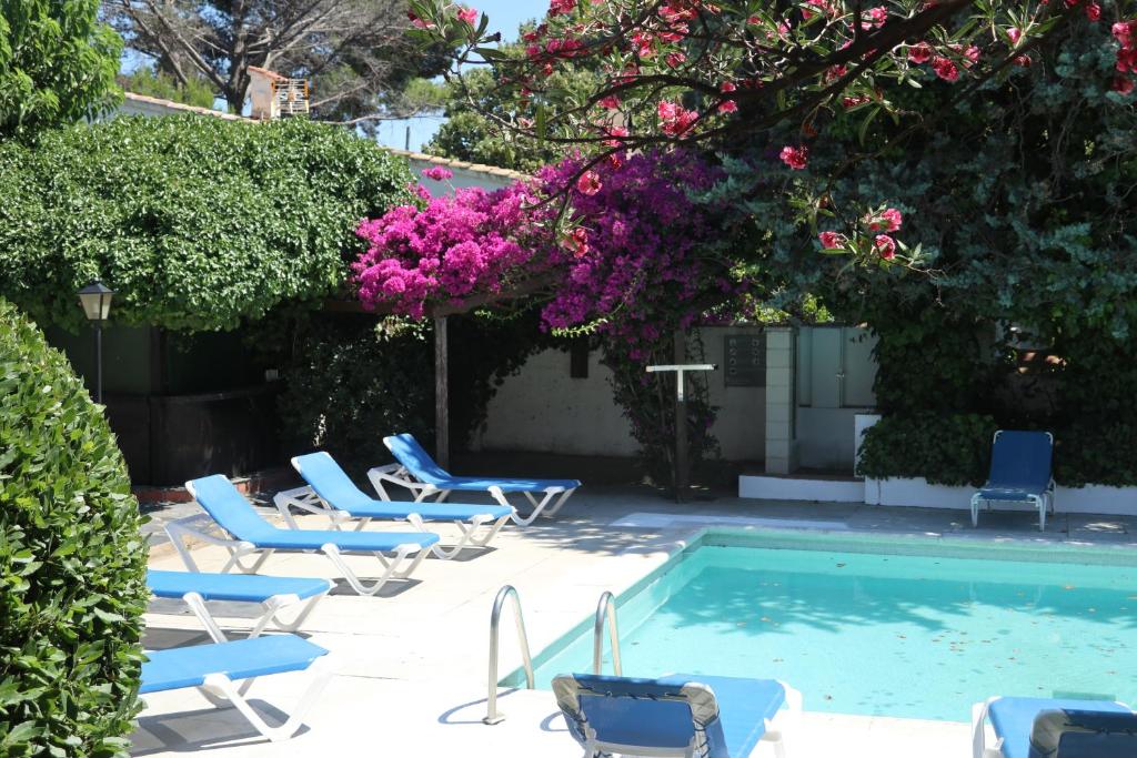 a group of chairs and a swimming pool with flowers at Hotel Misty in Cadaqués