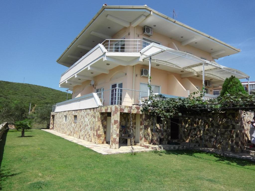 a large house with a stone wall at Villa Daniela Apartments in Nov Dojran