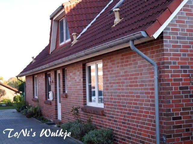 a red brick house with a red roof at ToNis-Wulkje-1 in Ditzum