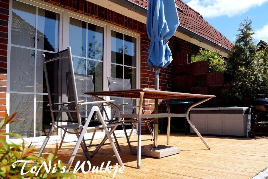 a table and two chairs and a blue umbrella at ToNis-Wulkje-2 in Ditzum