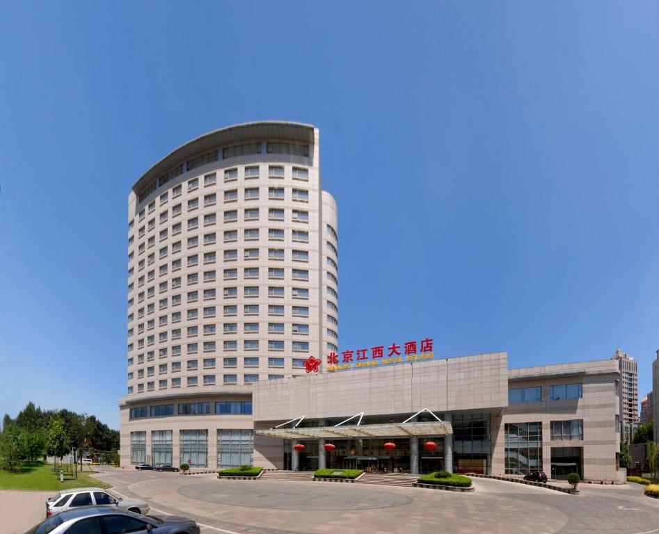 um grande edifício com um carro estacionado em frente em Jiangxi Grand Hotel Beijing em Pequim