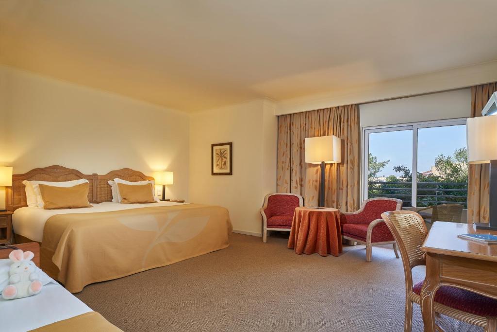 a hotel room with a bed and a table and chairs at PortoBay Falesia in Albufeira