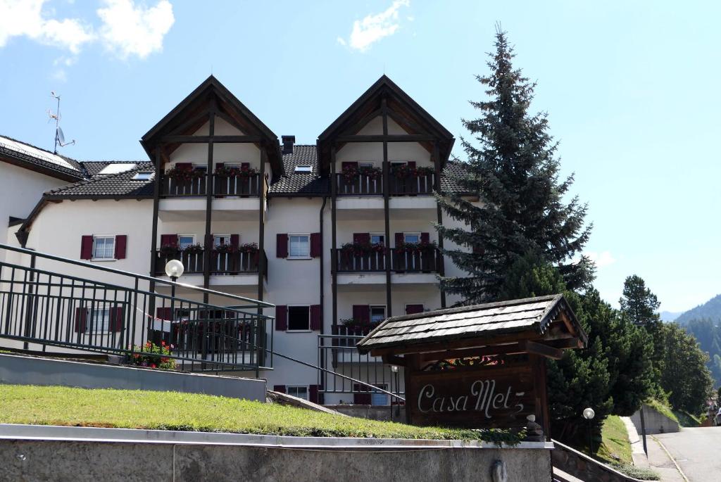 a large white building with a sign in front of it at Apartments Casa Metz in Santa Cristina in Val Gardena