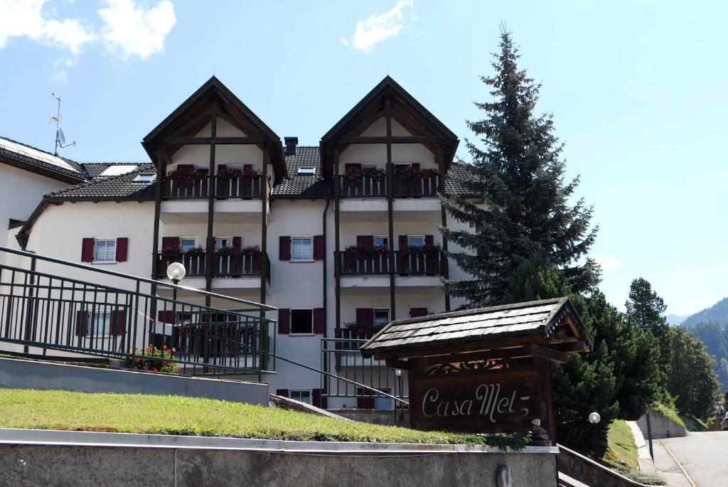 a large white building with a sign in front of it at Apartments Casa Metz in Santa Cristina Gherdëina