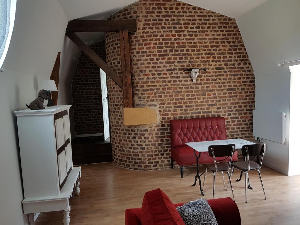 - un salon avec une table et un mur en briques dans l'établissement Appartement 3 pièces, à Sedan