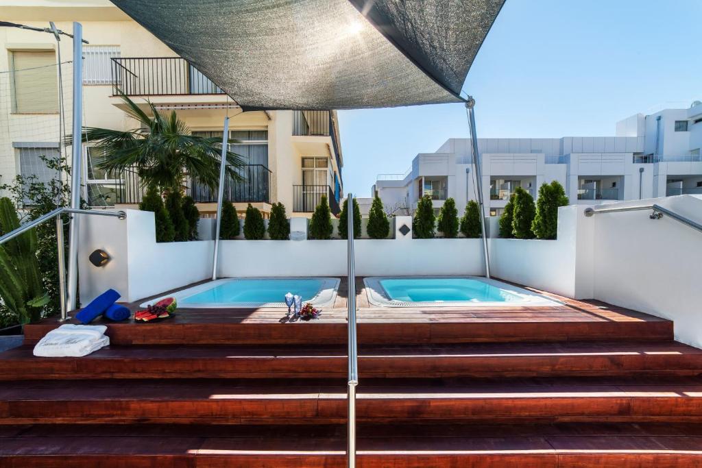 a swimming pool on the side of a building with an umbrella at Essence Hotel Boutique in Torremolinos