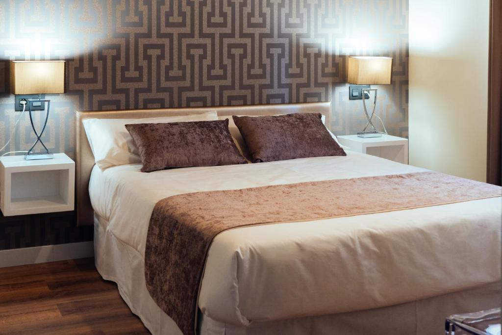 a bedroom with a large white bed with two lamps at Hotel Rural Pinares de Soria in Molinos de Duero