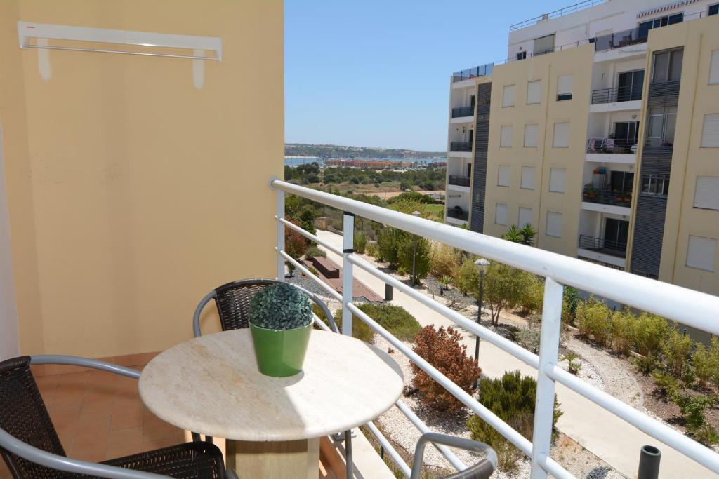 una mesa y sillas en un balcón con vistas en Apartamentos Encosta da Marina - Praia da Rocha, en Portimão