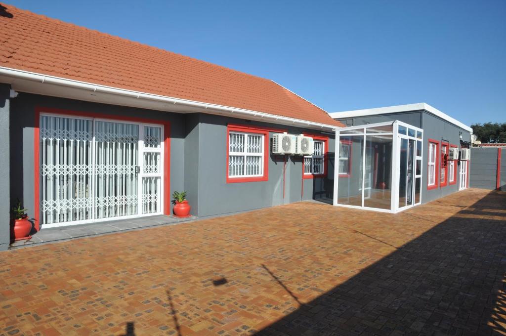 a building with white doors and a red roof at surrey b&b in Surrey Estate