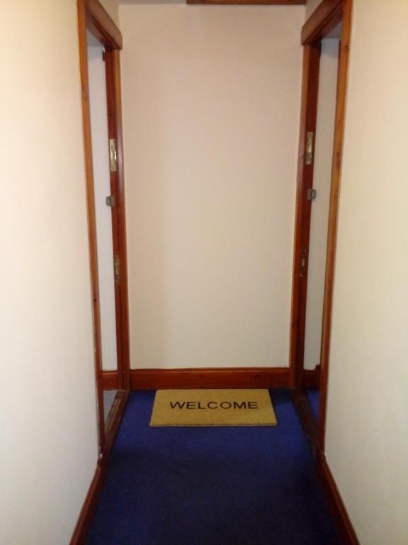 a room with a welcome sign on a blue carpet at West Brae Inn in Paisley