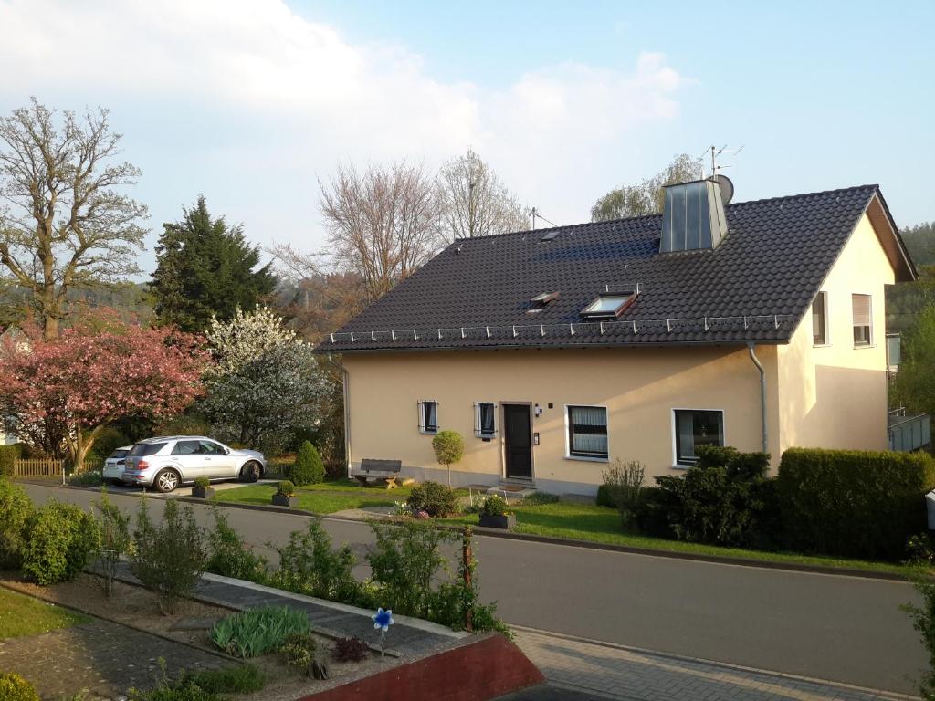 a white house with a black roof at Ferienwohnung Karin Vogel in Hilchenbach