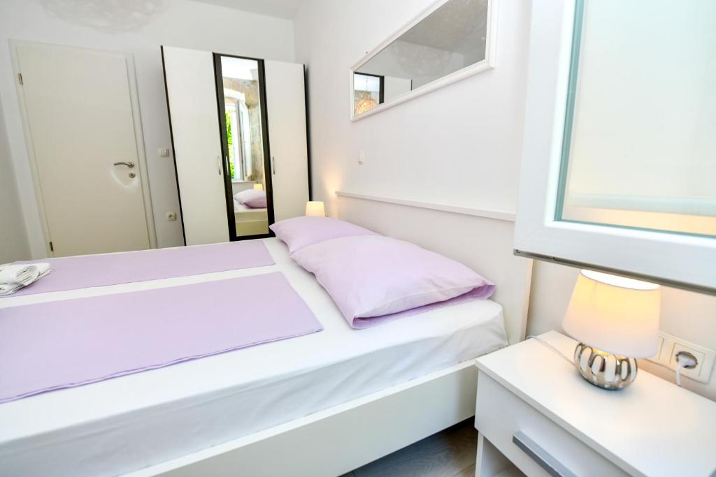 een kleine slaapkamer met 2 bedden en een spiegel bij Mila Apartment in Sinj