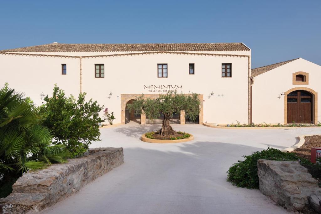 a large white building with a driveway at Momentum Wellness Bioresort in Marinella di Selinunte