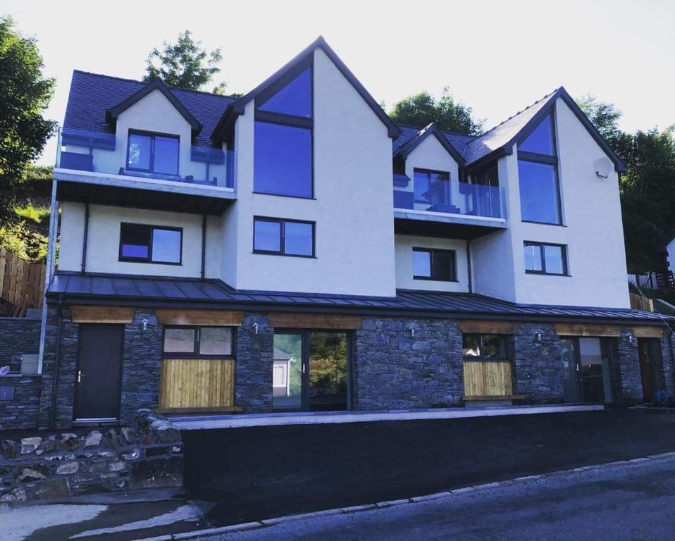 a large white building with windows on a street at Tianavaig View Apartments in Portree