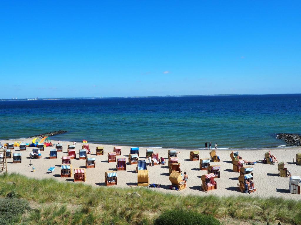 a beach with chairs and people on the beach at Strandhaus Niendorf in Niendorf