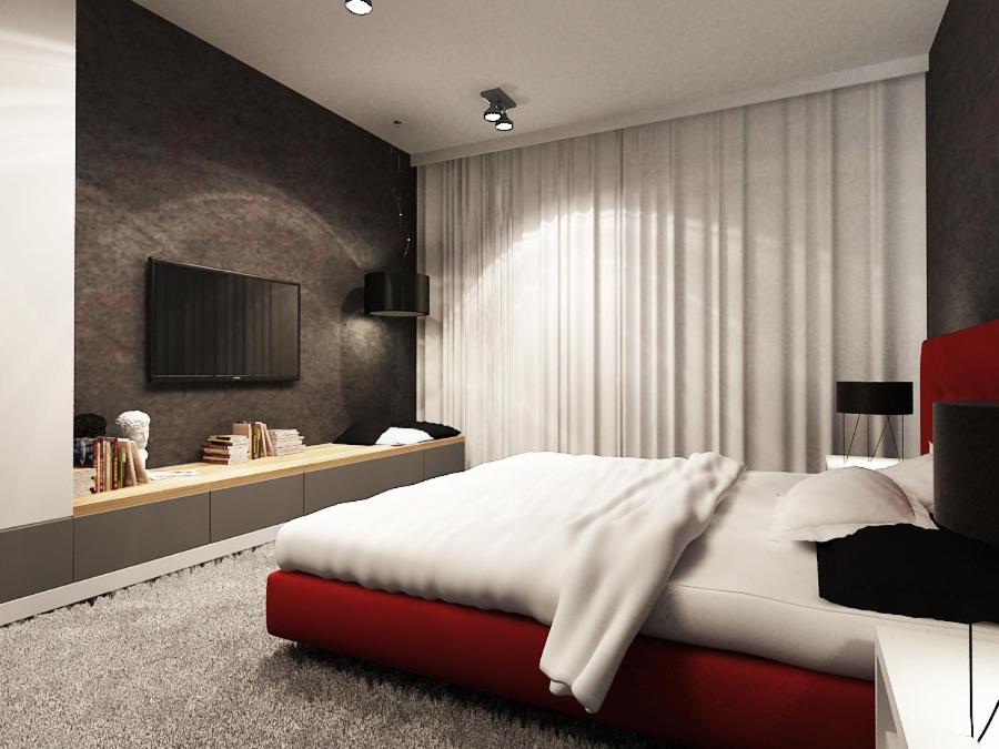 ビトムにあるLuksusowy Apartament w centrum 110m2のベッドルーム1室(ベッド1台、壁にテレビ付)