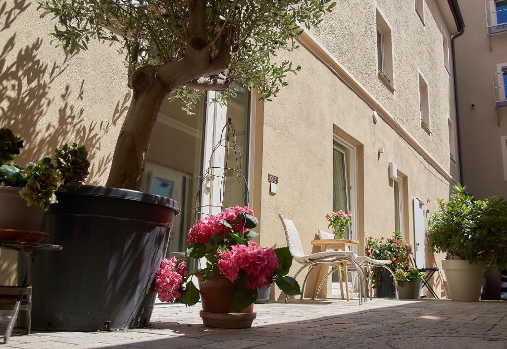 a patio with potted plants and a table and chairs at Hotel am Peterstor in Regensburg