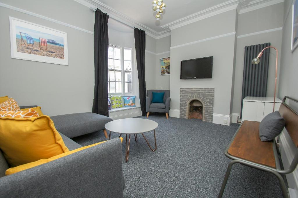 ein Wohnzimmer mit einem Sofa und einem Kamin in der Unterkunft Mucky Duck House - Central- by Brighton Holiday Lets in Brighton & Hove