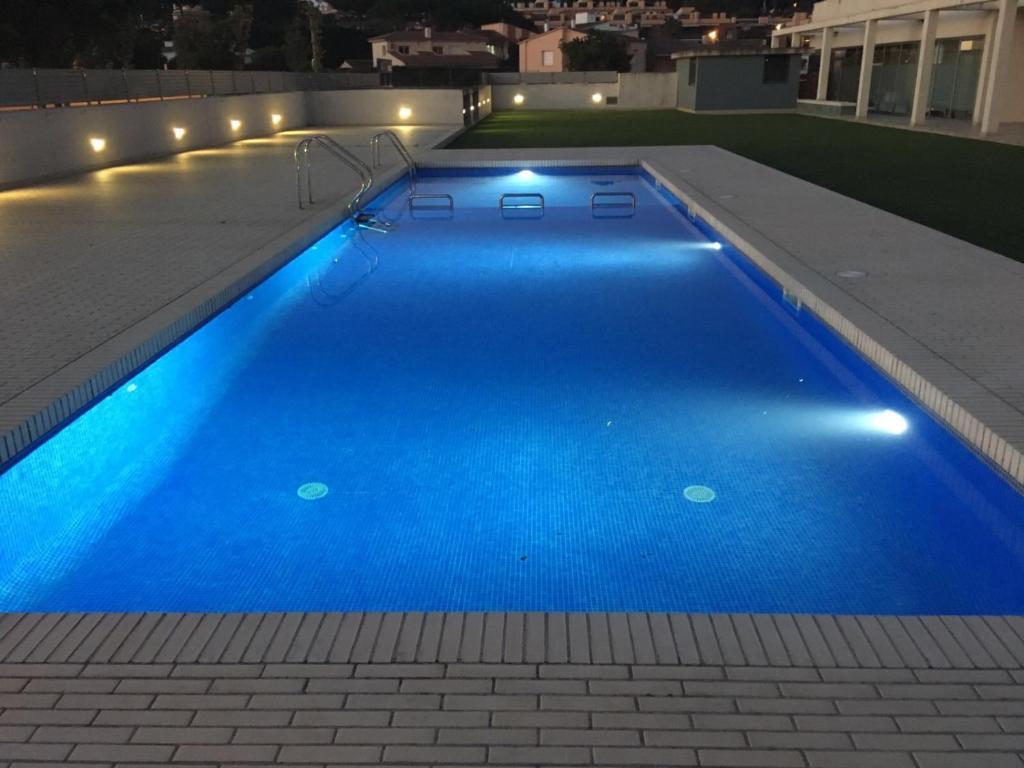 una piscina azul con luces en la parte superior de un edificio en Apartment Ramon, en Sant Antoni de Calonge