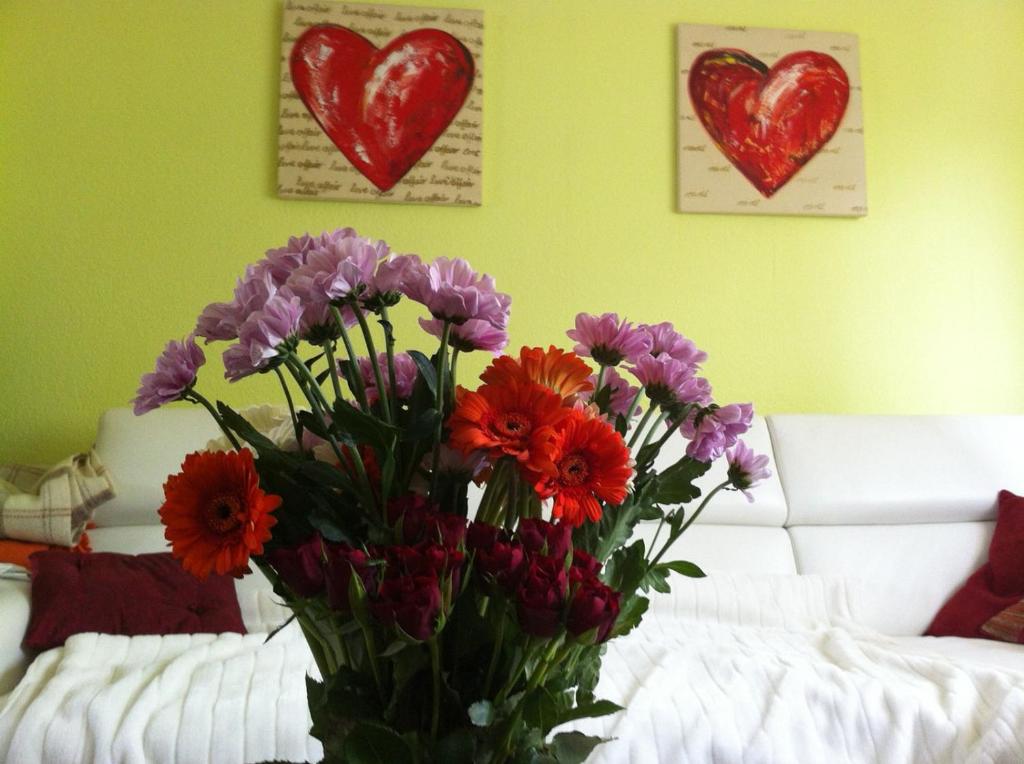 un vase de fleurs dans une pièce avec deux cœurs dans l'établissement Traumhaftes Apartment in Mönchengladbach Ohler, à Mönchengladbach