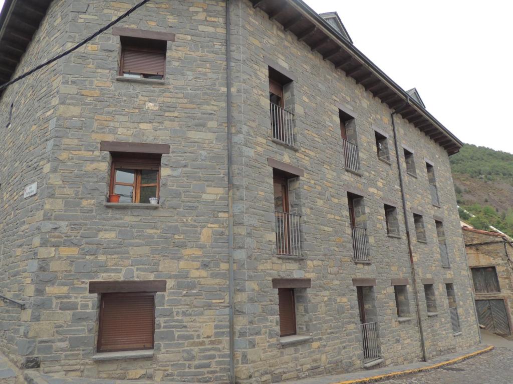 a large brick building with windows on the side at Apartamento céntrico con WIFI en Biescas in Biescas