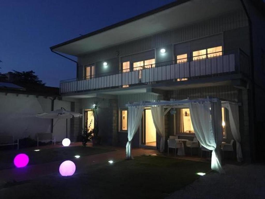 una casa con una cortina blanca delante de ella por la noche en City Garden Guest House en Olbia