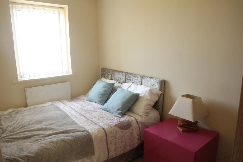 a small bedroom with a bed with a window at Bright modern house beside Snowdonia in Llanfairfechan