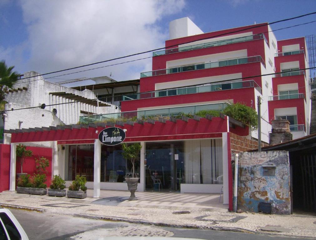 un edificio rojo con un cartel delante en Don Limpone Apart Hotel, en Natal