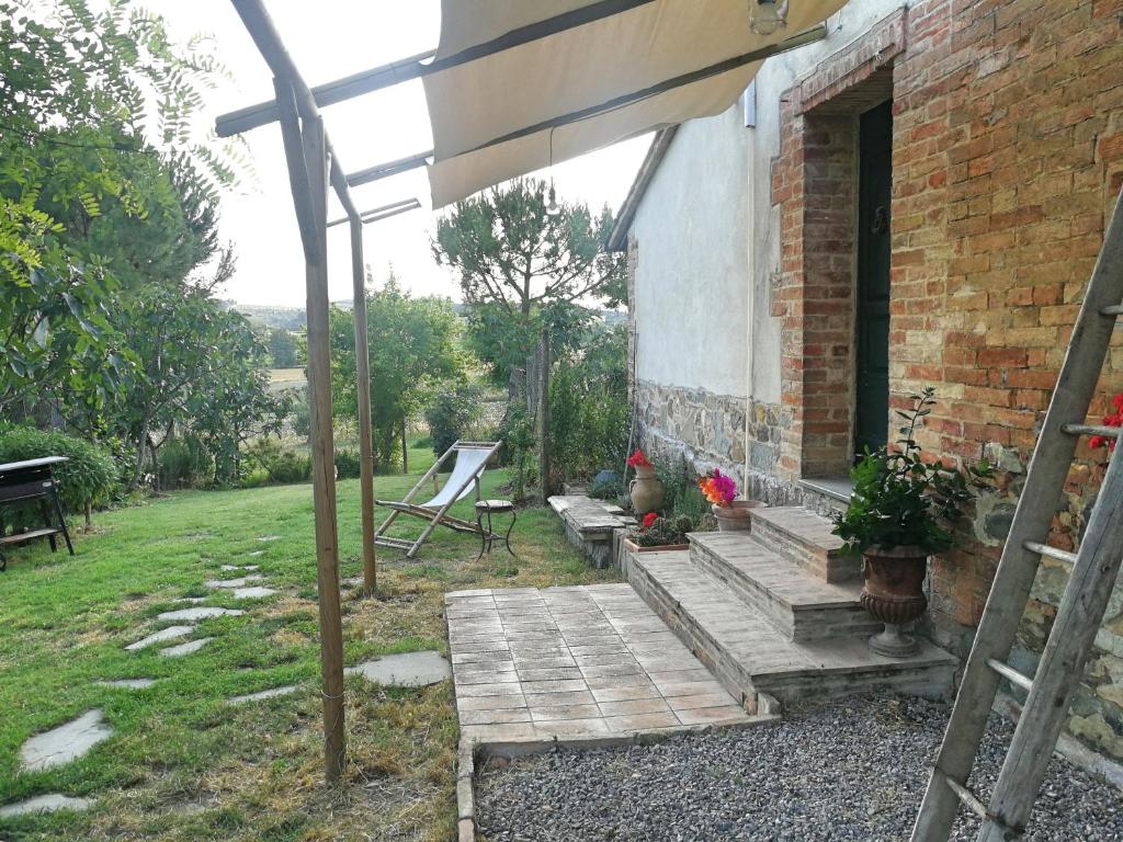 a porch of a brick house with a wooden deck at Il Saragio in Abbadia di Montepulciano