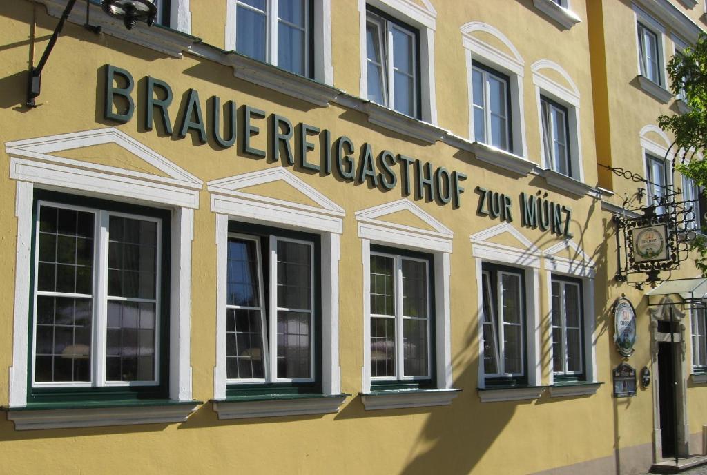 ein gelbes Gebäude mit einem Schild an der Seite in der Unterkunft Brauereigasthof zur Münz seit 1586 in Günzburg