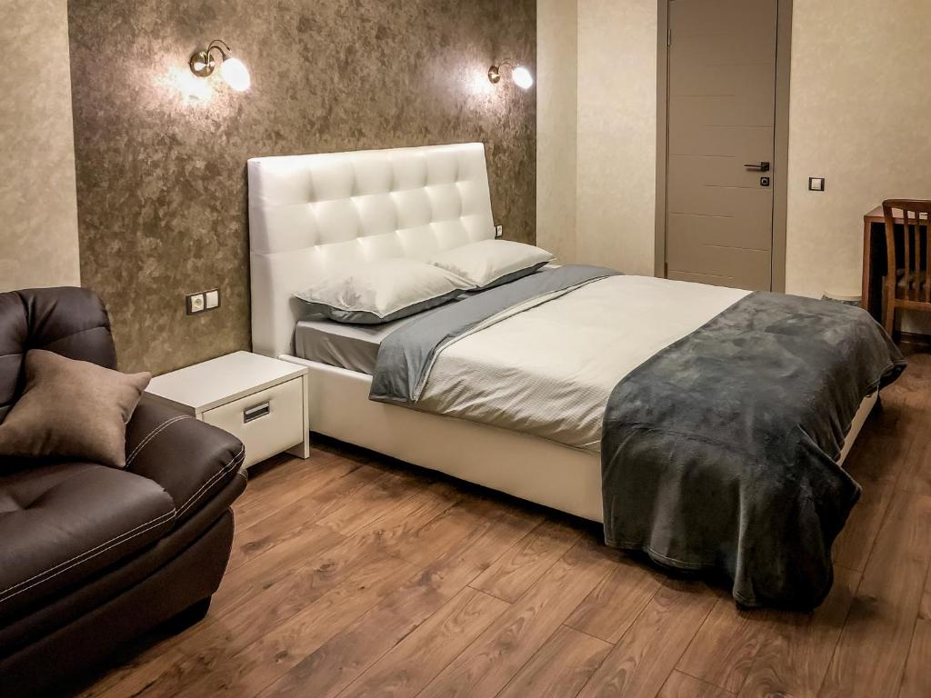 ケメロヴォにあるБутик-Отель GUESTHOUSEのベッドルーム(大型ベッド1台、ソファ付)