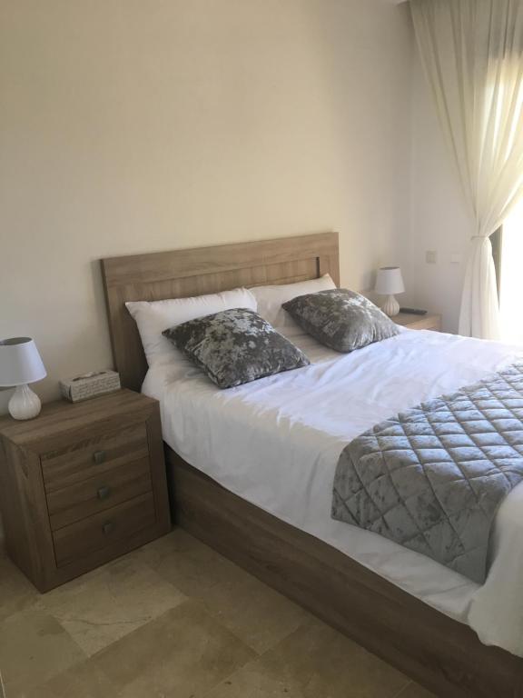 a bedroom with a bed and a night stand with two pillows at Roda Golf Resort Los Alcazares in San Javier