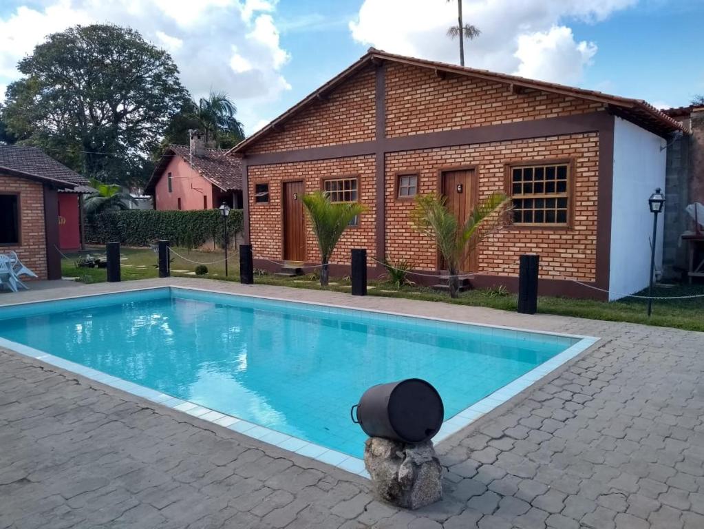 a swimming pool in front of a house at Pousada Império estrada Real in Santa Cruz de Minas
