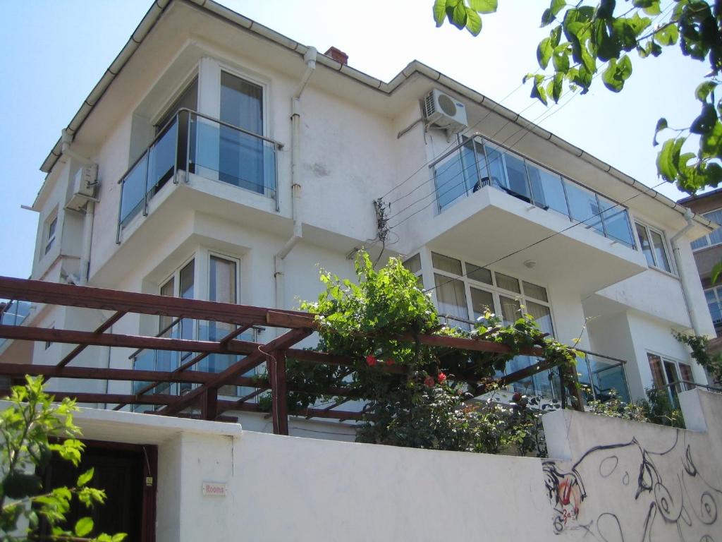 a white building with windows and plants on a wall at Guest House Fanari in Sozopol