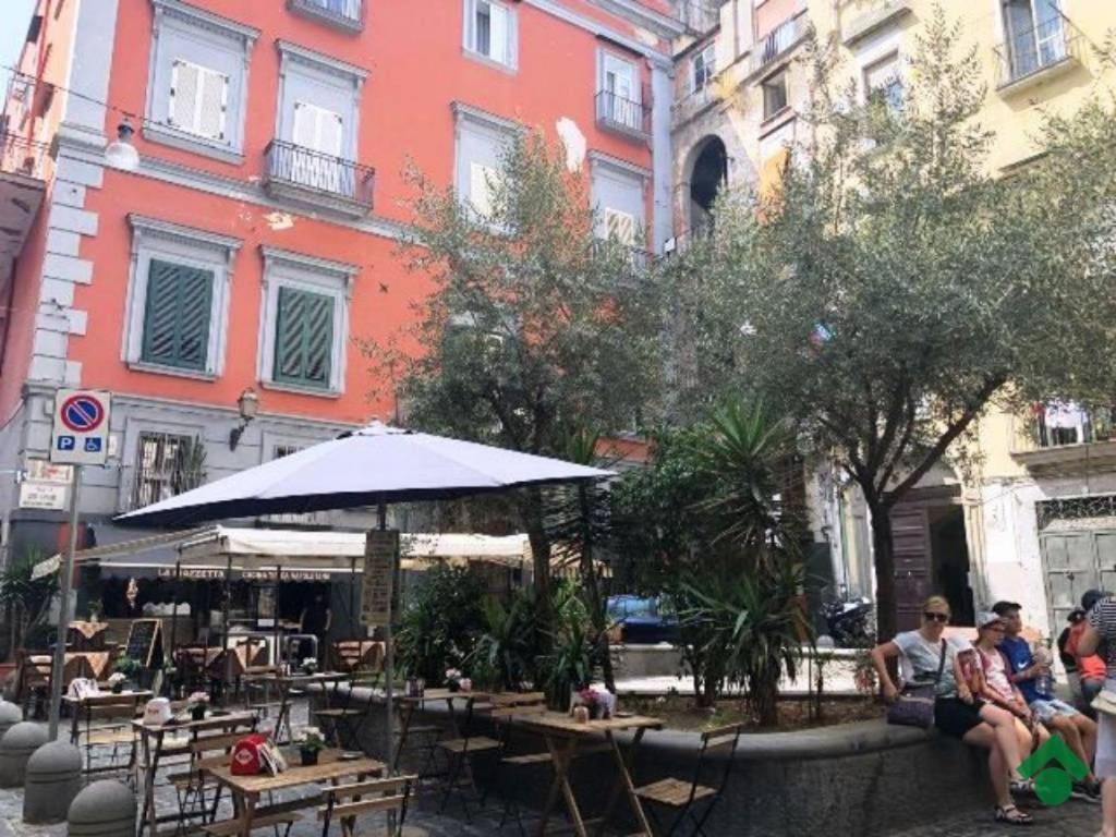 een groep mensen die aan tafels voor een gebouw zitten bij Casa vacanza Da Totore in Napels