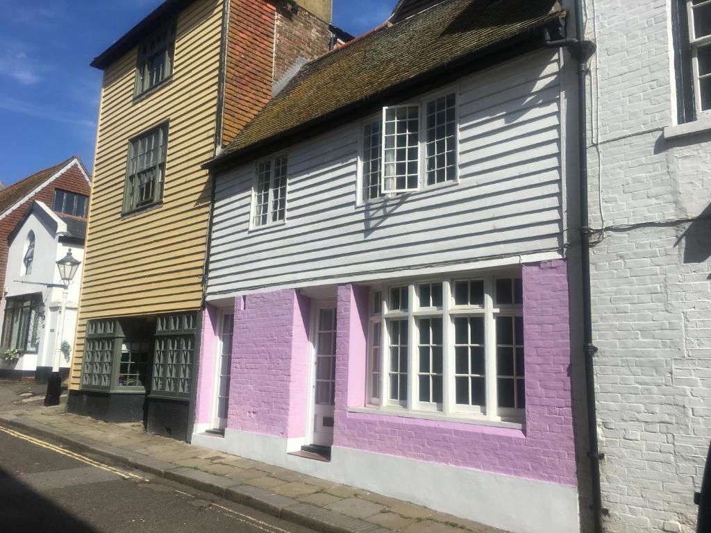 um grupo de casas pintadas com cores diferentes numa rua em The Cottage with free parking em Hastings